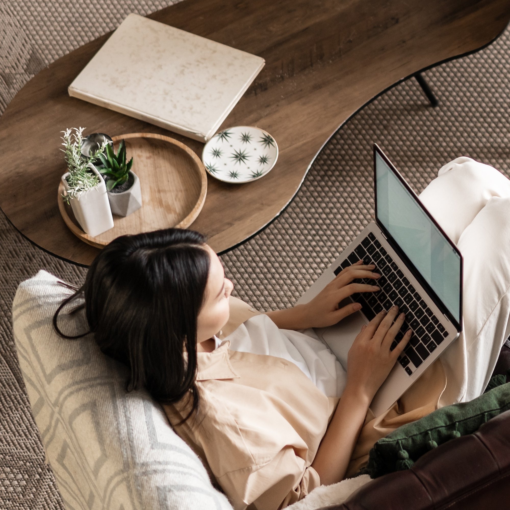 upper-angle-shot-young-asian-woman-laying-couch-using-laptop-working-computer-studyi
